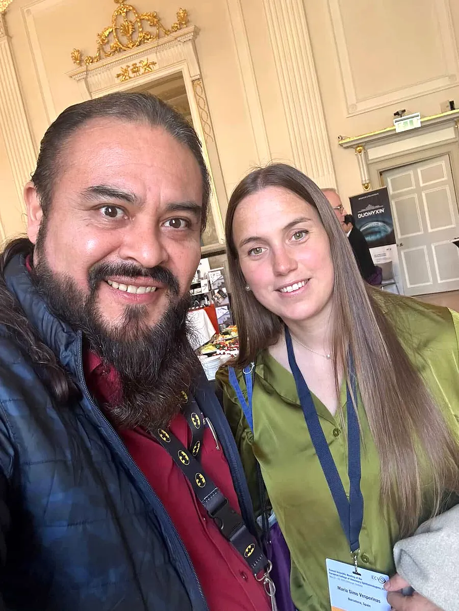 Selfie de la Dra. María Simó con Alexis Montes en el interior del recinto del ECVO 2025, ambos con acreditaciones visibles.